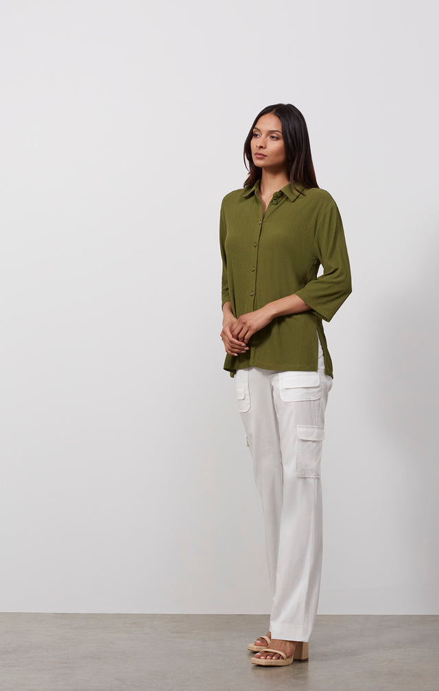 Ecomm photo of a model wearing the Areca shirt, which is a high-low knit tunic with side slits.