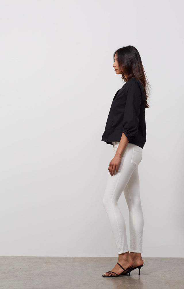 Ecomm photo of a model wearing the Doyenne shirt, which is a stretch cotton black blouse.