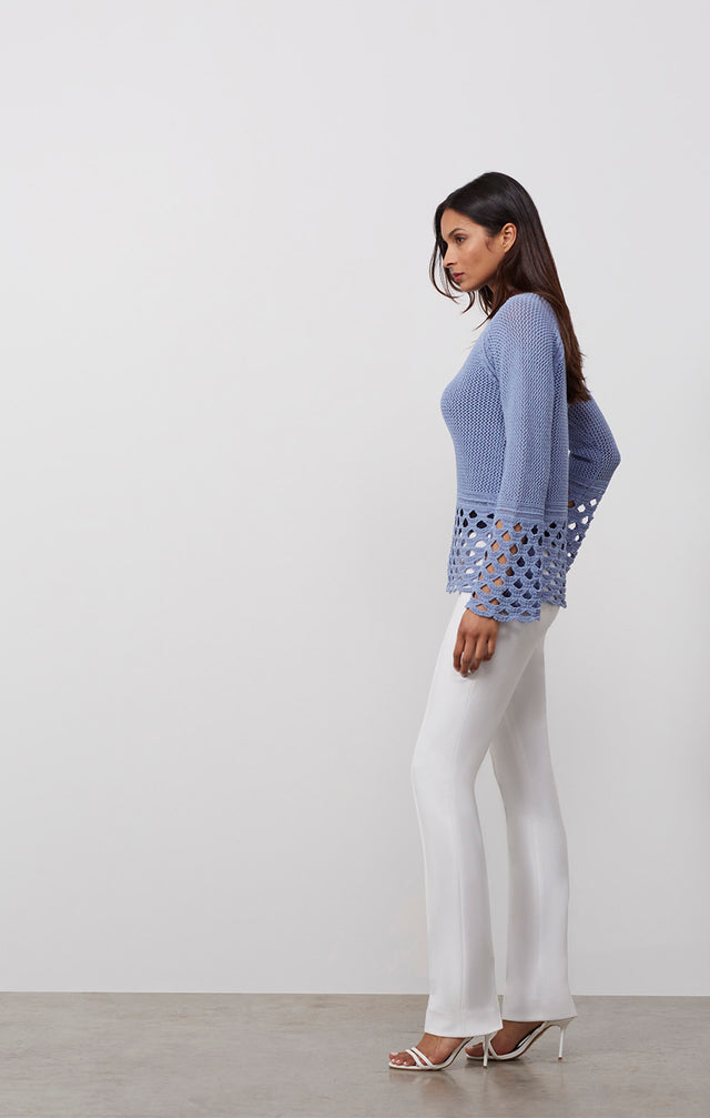 Ecomm photo of a model wearing the Riviera sweater, which is a crochet-look textured pullover.