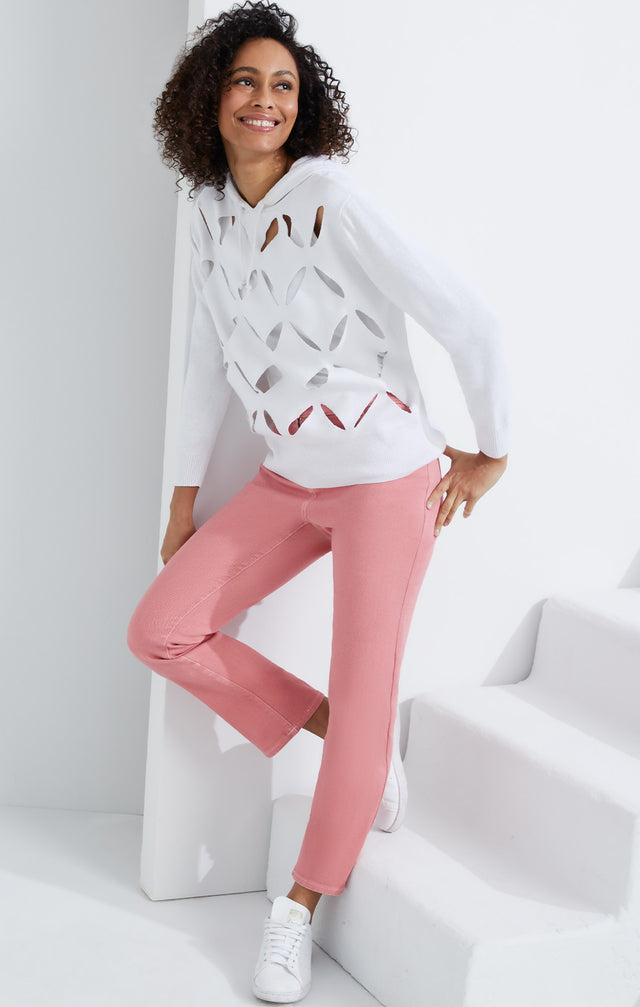 Lookbook photo of a model wearing the Palm Beach sweater, which is a hooded knit top with petal cutouts.